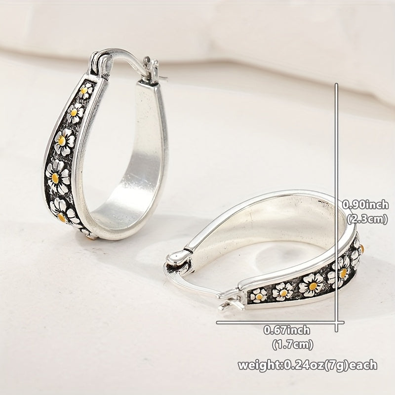 Brushed silver-tone oval hoop earrings with small gold-tone daisy motifs