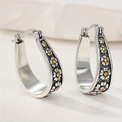 Brushed silver-tone oval hoop earrings with small gold-tone daisy motifs