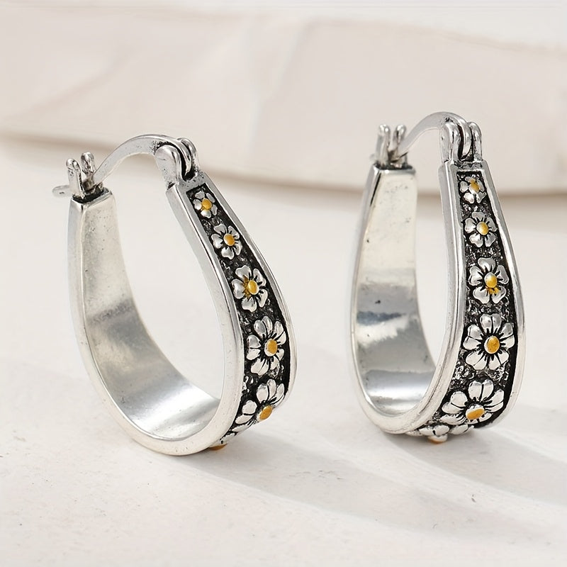 Brushed silver-tone oval hoop earrings with small gold-tone daisy motifs