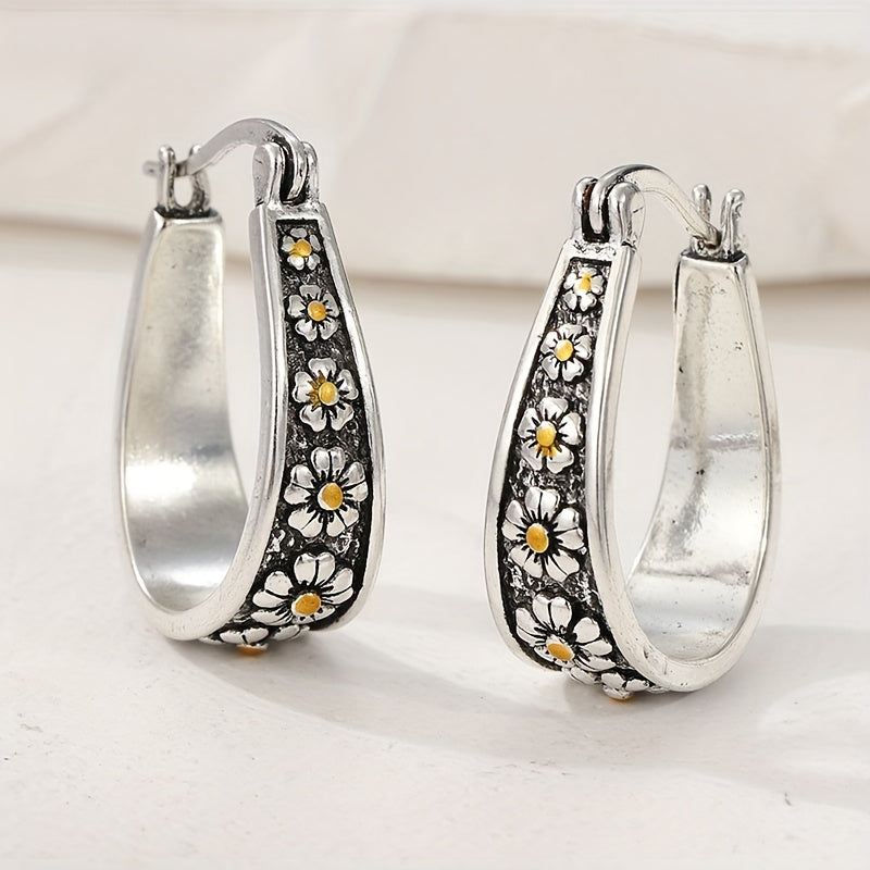 Brushed silver-tone oval hoop earrings with small gold-tone daisy motifs