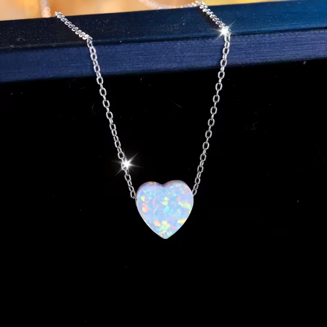 Close-up of the white opal heart pendant showing the pink and green flecks in the stone