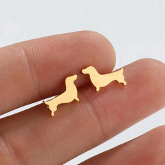 Dachshund stud earrings in gold tone resting on fingers