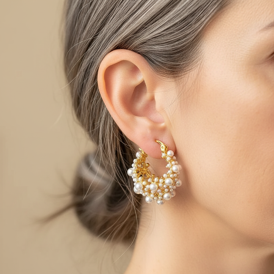 Gold-tone hoop earrings covered in clusters of small cream faux pearls