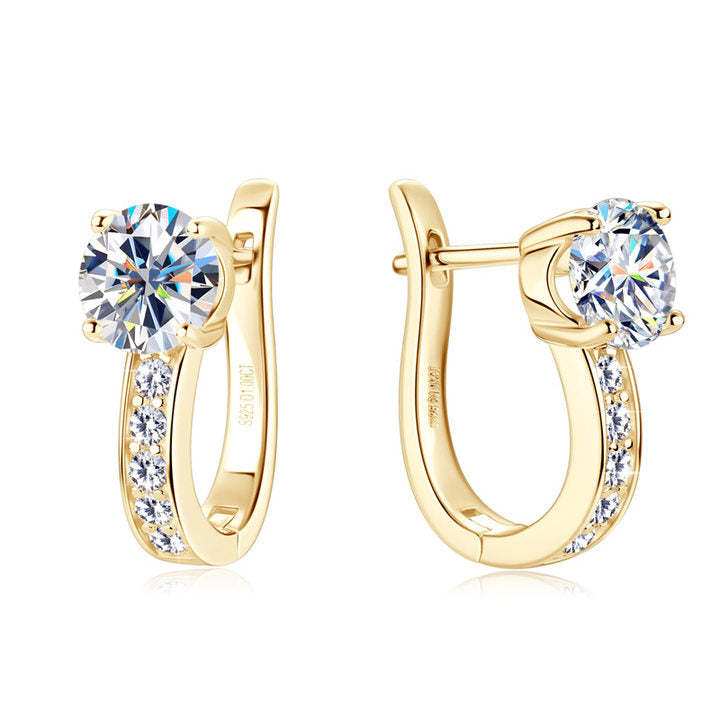Gold-tone huggie hoop earrings with a large claw-set clear stone and a row of smaller stones down the band