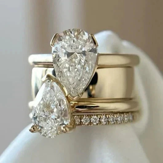 Gold-tone statement ring with two large pear-cut crystals above a pave band