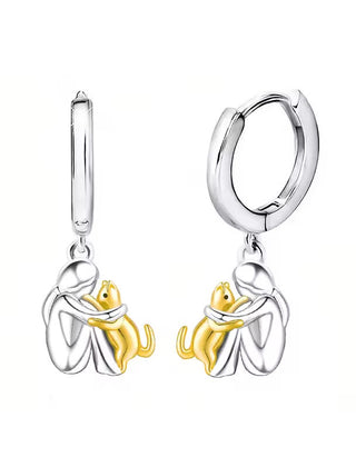 Huggie hoop earrings with the figure and cat in gold tone