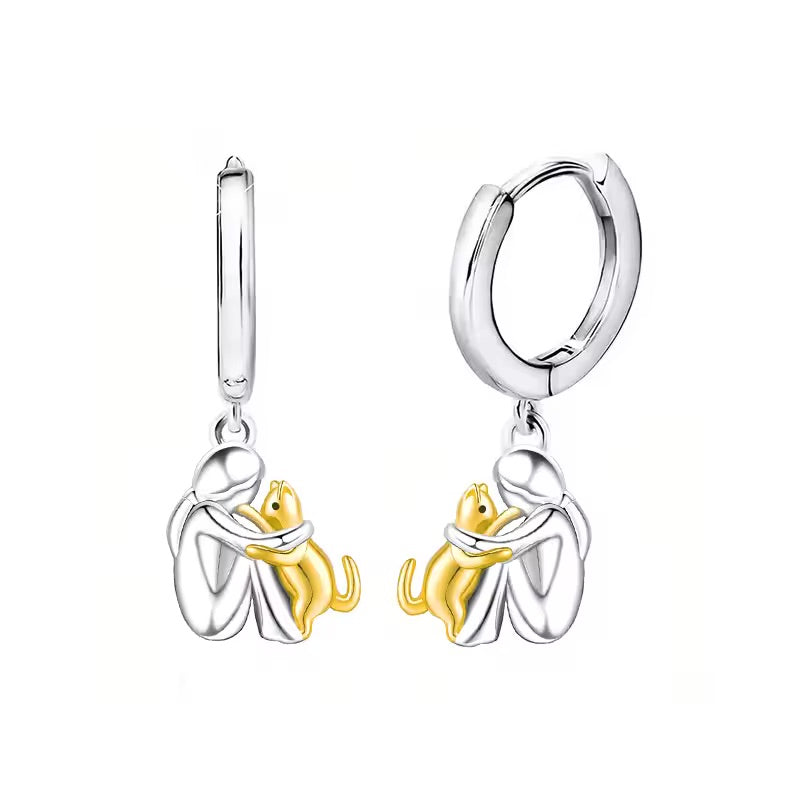 Huggie hoop earrings with the figure and cat in gold tone