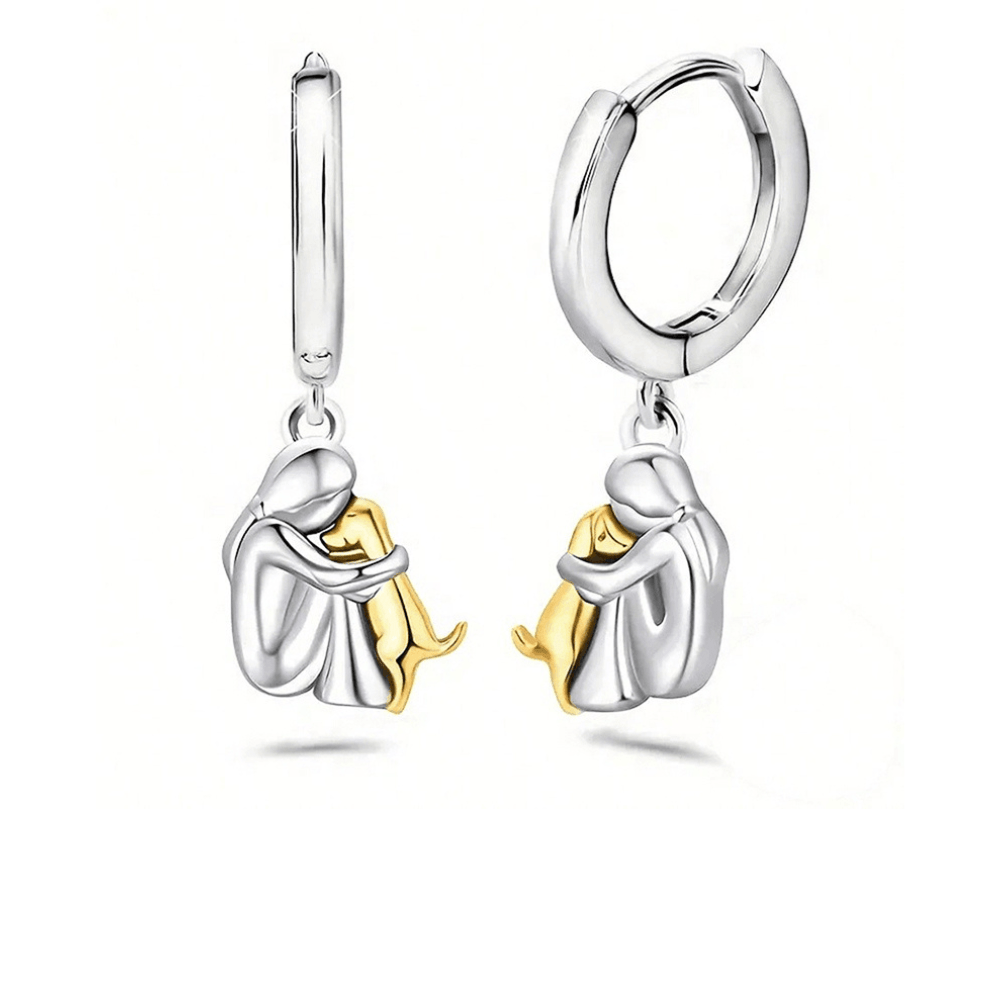 Matching huggie earrings, each with a seated figure hugging a gold-tone dog
