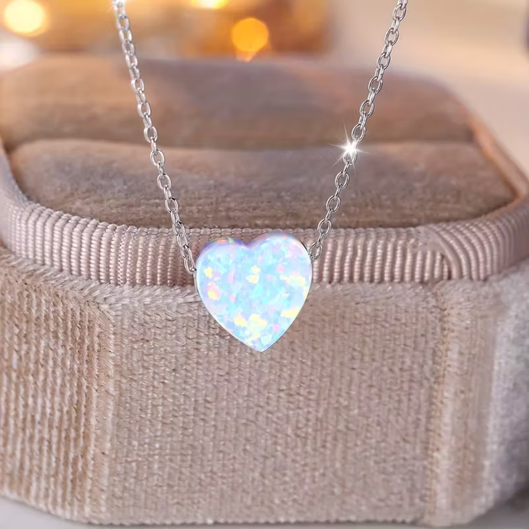 Opal heart necklace on a fine silver-tone chain, resting on a velvet jewellery box