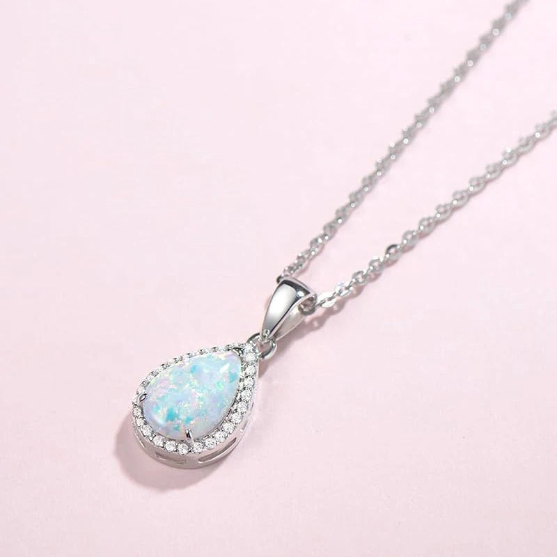 Opal teardrop pendant necklace with a halo of small clear stones on a fine silver-tone chain