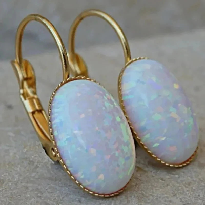 Pair of opal earrings with large oval white opal cabochons in rope-edged gold-tone bezels and leverback closures