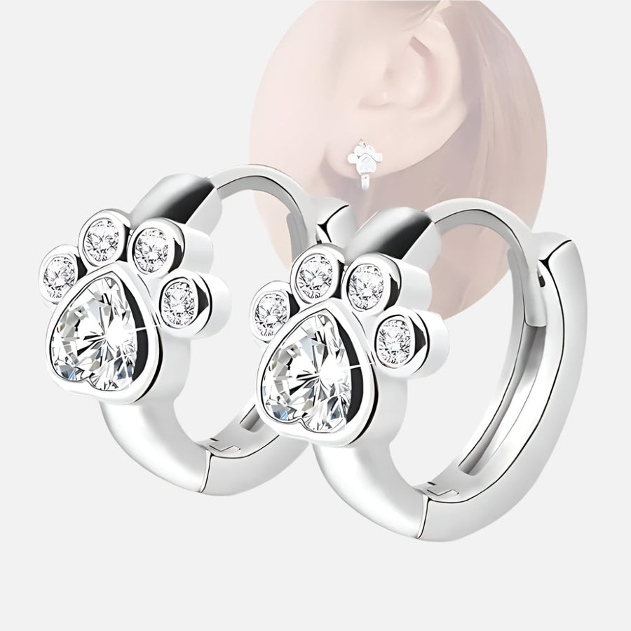 Pair of silver-tone huggie hoop earrings with a sparkling paw motif on the front