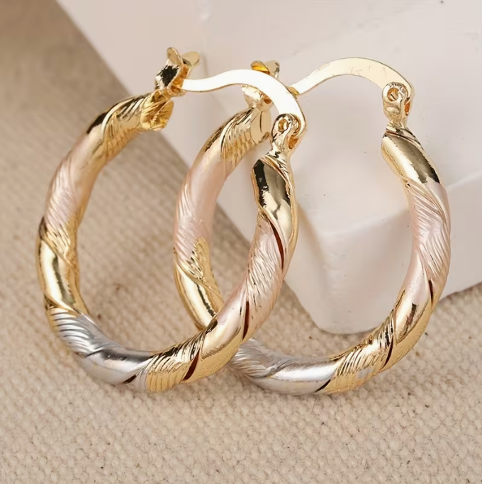 Pair of three tone twisted hoop earrings seen from the front