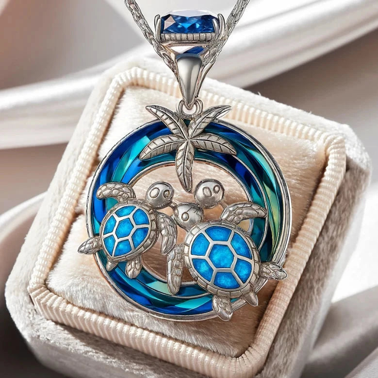 Round silver-tone pendant with two sea turtles in blue opal-look inlay under a palm tree