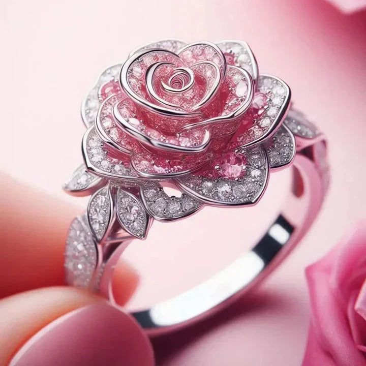 Silver-tone flower ring shaped as an open rose with pink stones in the petals and clear pave on the leaves