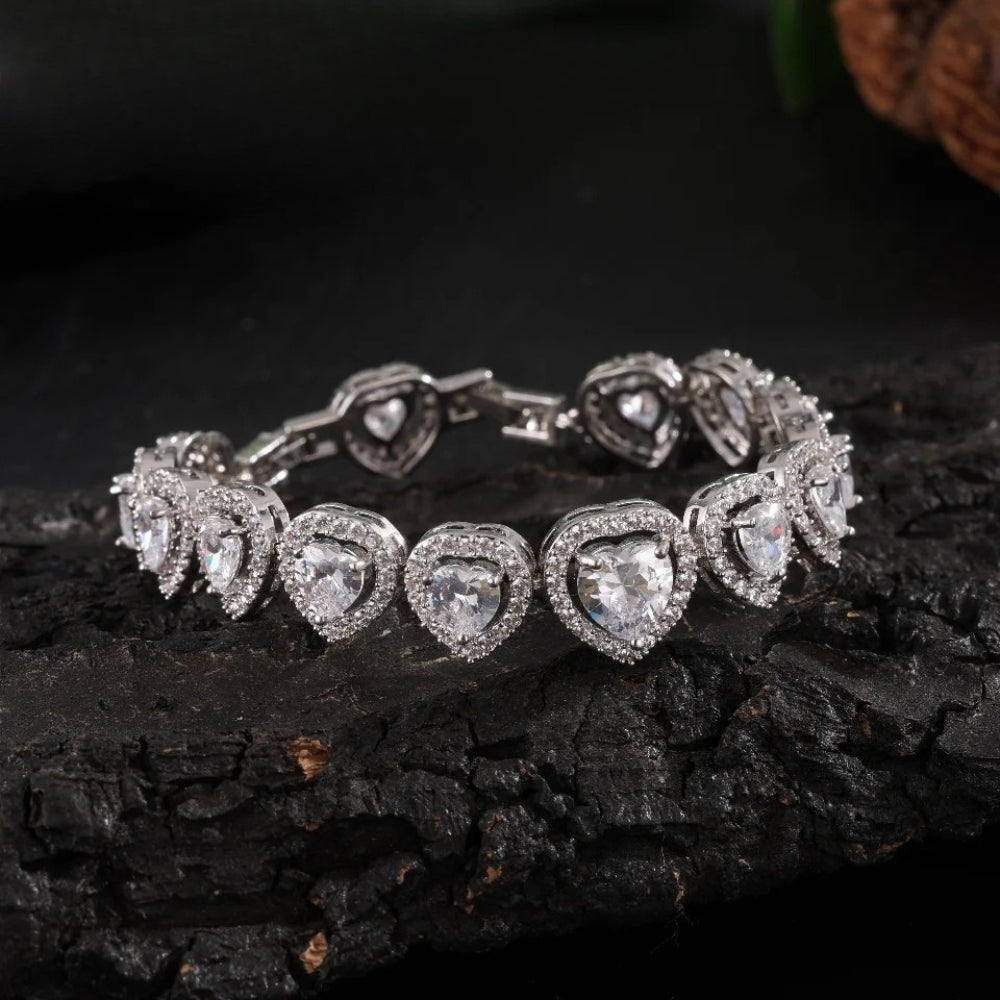 Silver-tone tennis bracelet with a line of heart-cut clear stones, each in a halo of smaller stones