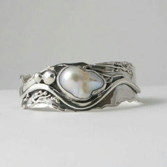 Silver-tone wave ring holding an irregular baroque faux pearl