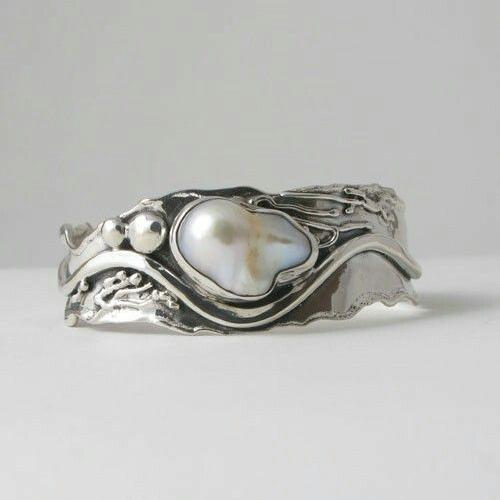 Silver-tone wave ring holding an irregular baroque faux pearl