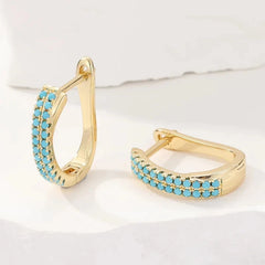 Slim gold-tone huggie hoop earrings with two rows of turquoise-effect pave