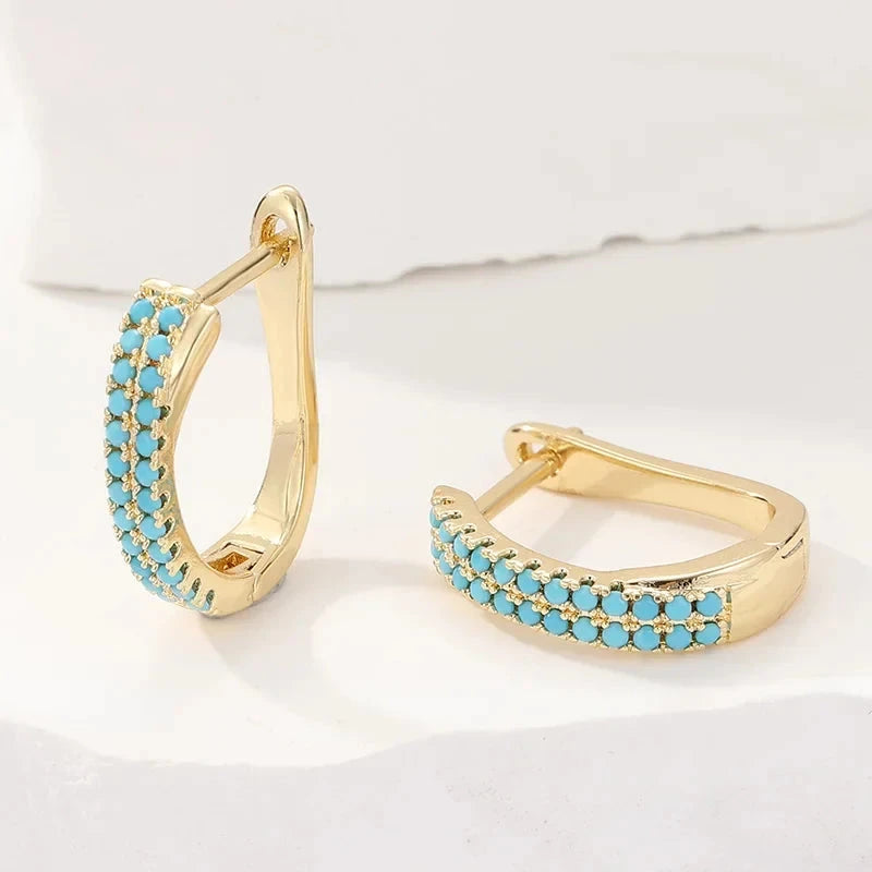 Slim gold-tone huggie hoop earrings with two rows of turquoise-effect pave