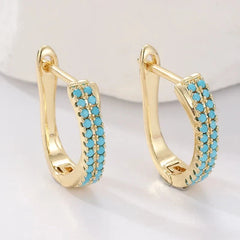 Slim gold-tone huggie hoop earrings with two rows of turquoise-effect pave