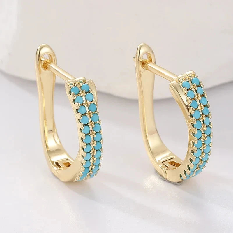 Slim gold-tone huggie hoop earrings with two rows of turquoise-effect pave