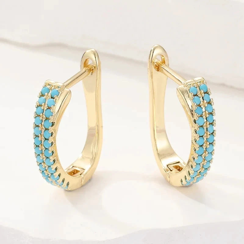 Slim gold-tone huggie hoop earrings with two rows of turquoise-effect pave