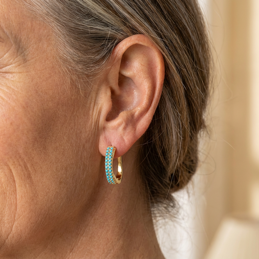Slim gold-tone huggie hoop earrings with two rows of turquoise-effect pave