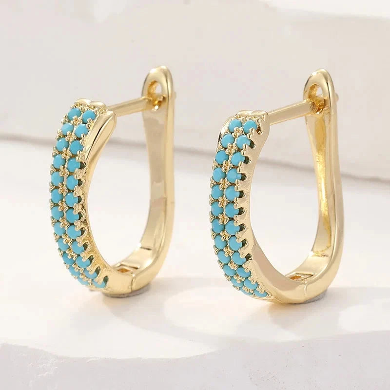 Slim gold-tone huggie hoop earrings with two rows of turquoise-effect pave