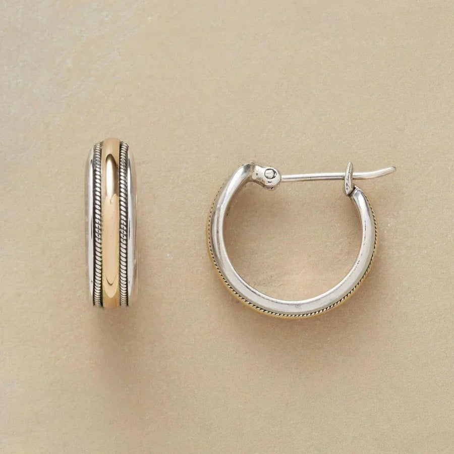 Small two-tone hoop earrings in silver tone with a gold-tone centre band and a hinged snap post