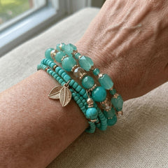 Stack of four turquoise and green beaded stretch bracelets