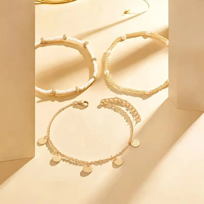 The anklet set styled on a sand-coloured background