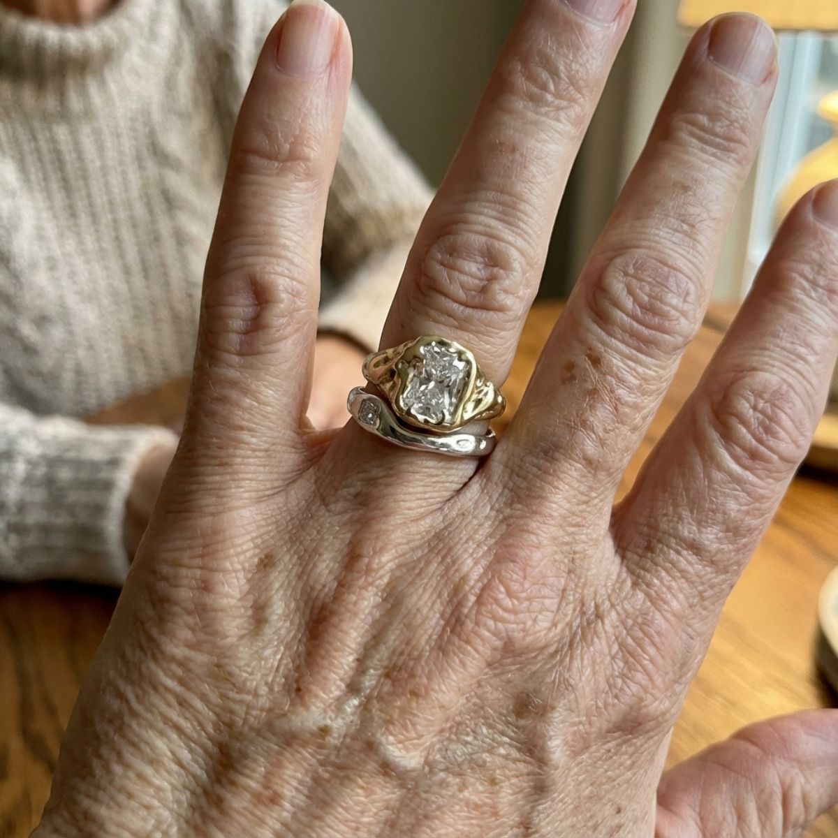 Two-tone stacking ring set with a wide emerald-cut clear stone