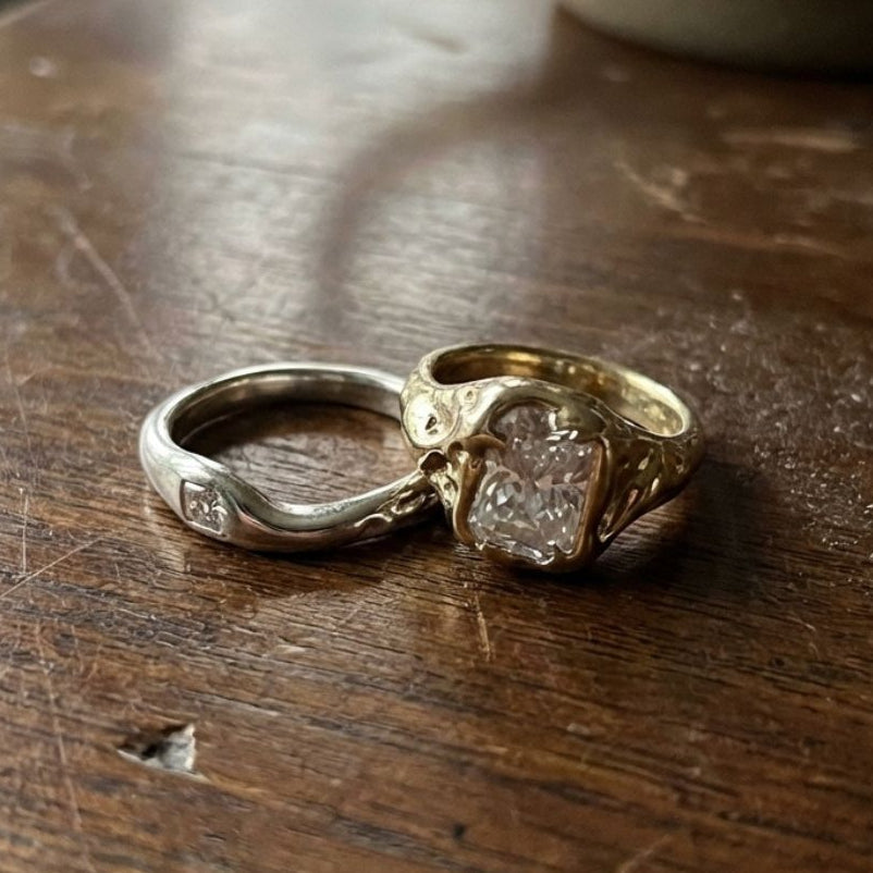 Two-tone stacking ring set with a wide emerald-cut clear stone