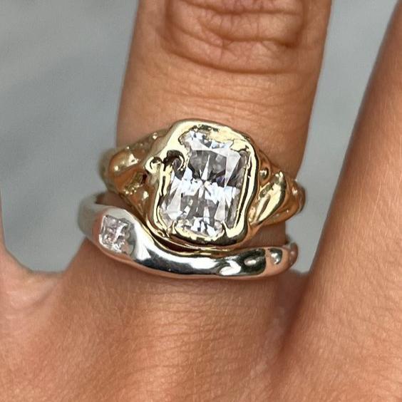 Two-tone stacking ring set with a wide emerald-cut clear stone