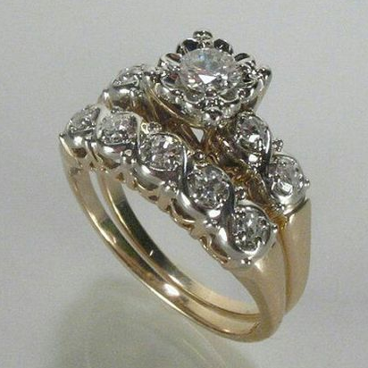 Vintage-style gold-tone ring with a raised clear centre stone and rows of smaller stones