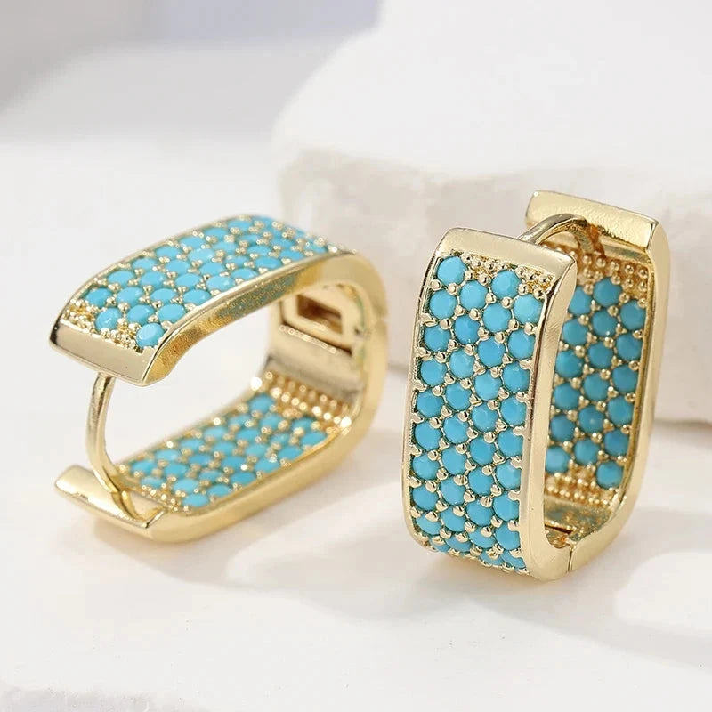 Wide gold-tone huggie hoop earrings pave set with turquoise-effect stones