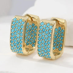 Wide gold-tone huggie hoop earrings pave set with turquoise-effect stones